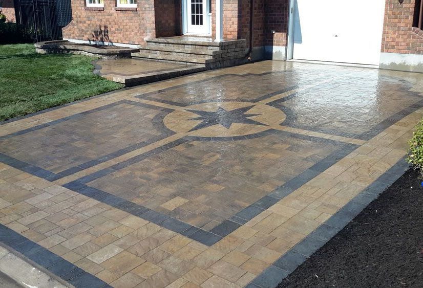 Une allée en briques avec un motif en étoile au milieu se trouve devant une maison.
