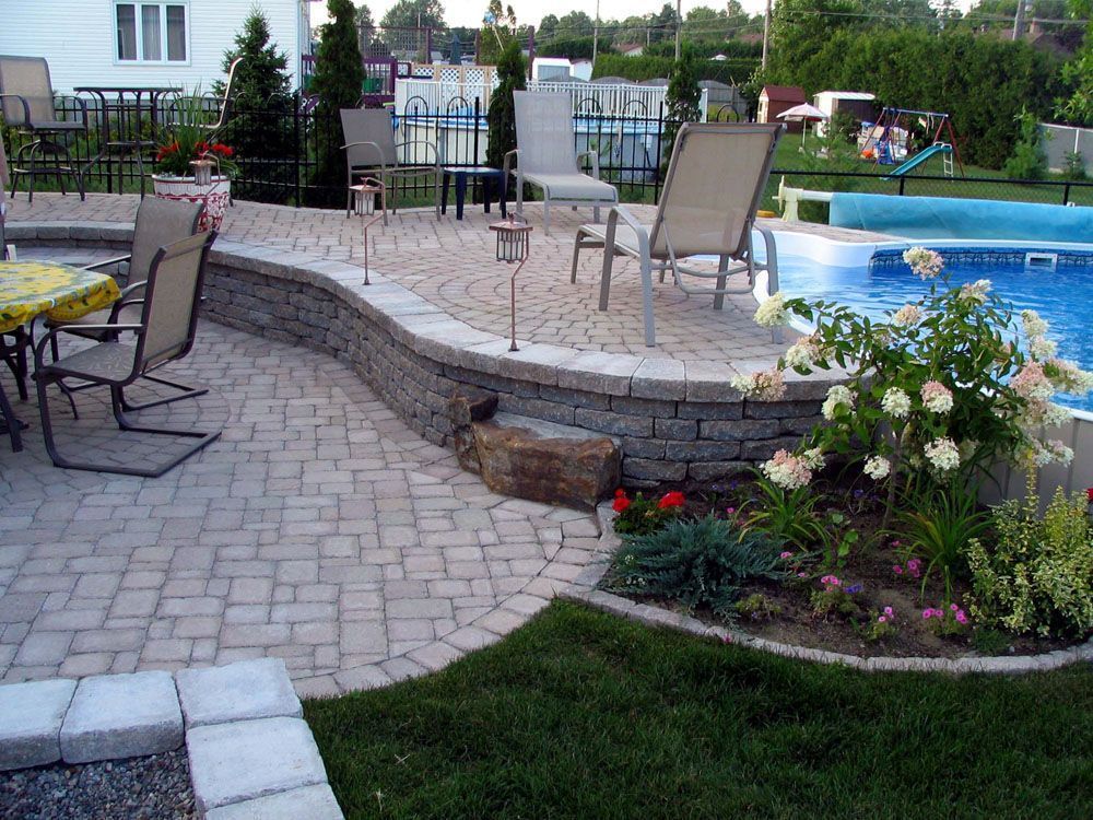 Un patio avec des chaises et une table à côté d'une piscine