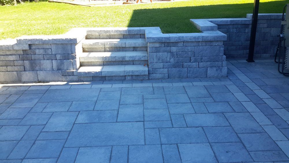 Un patio avec des escaliers et un mur dans la cour arrière