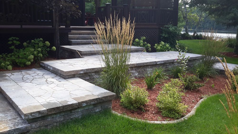 Un patio avec marches et plantes dans une cour arrière.