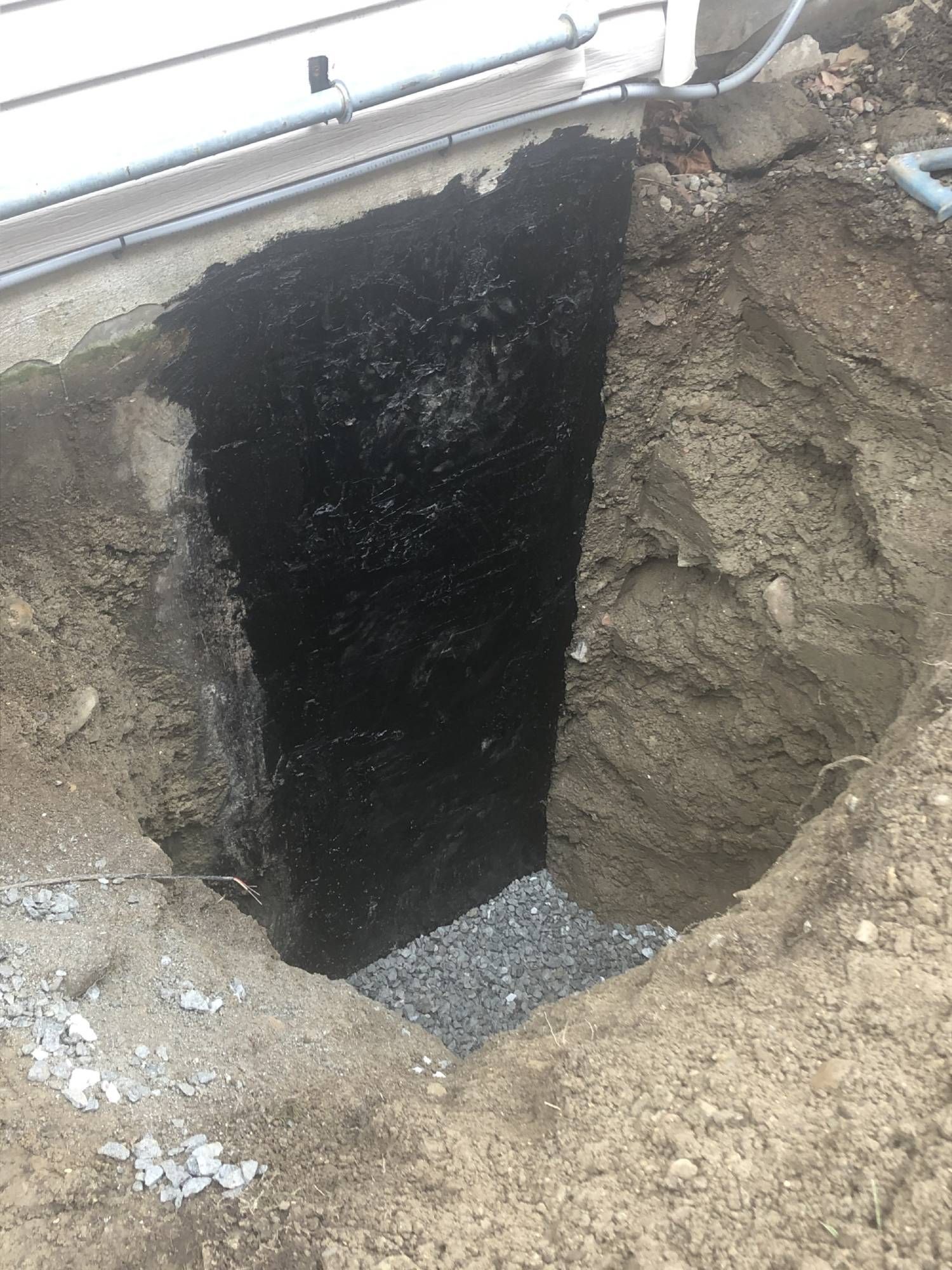 A large hole in the ground next to a house.
