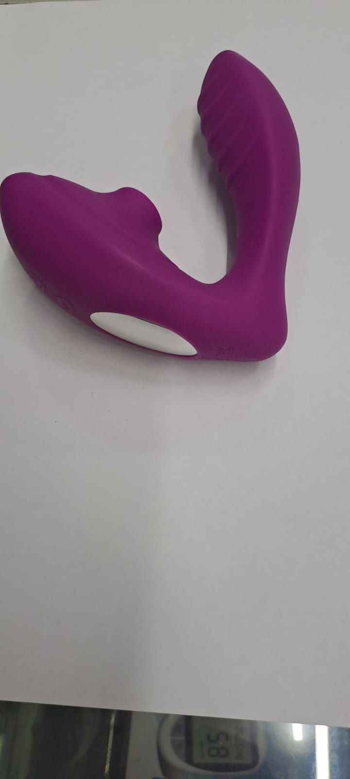 Juguete sexual morado sobre una superficie blanca.