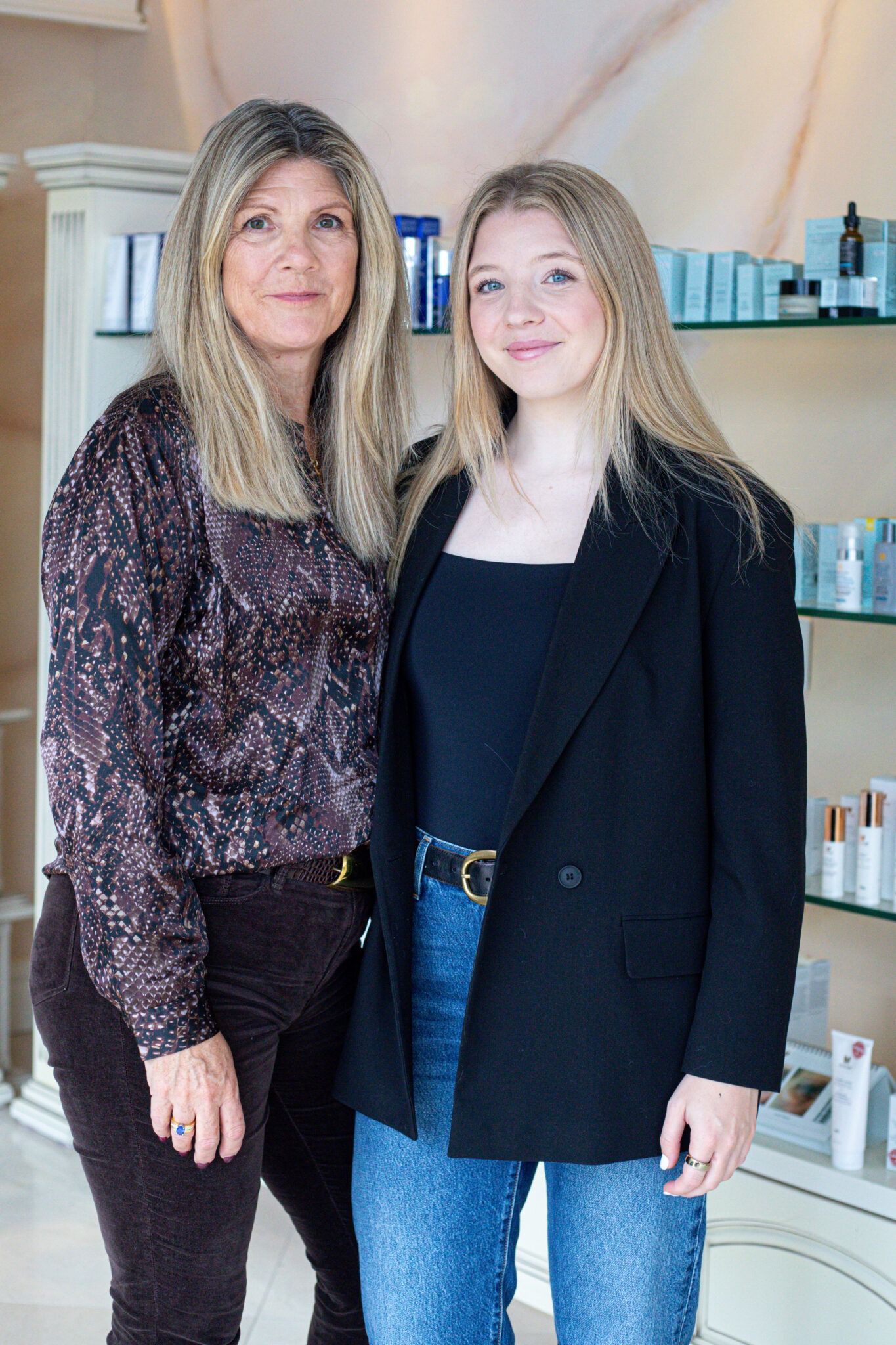 Woman administering cosmetic procedure to a patient's lips, observed by onlookers in an illuminated setting.