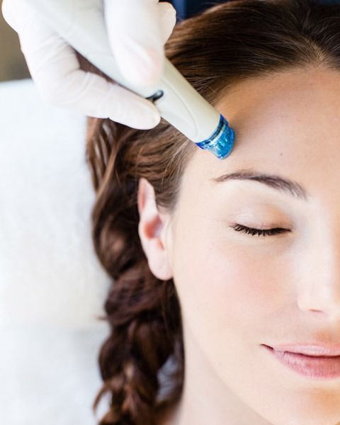 Person receiving facial treatment on forehead with closed eyes.