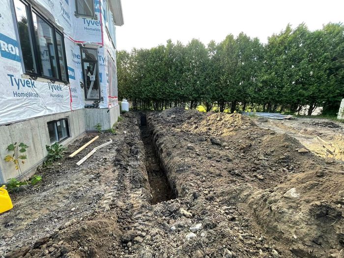 Un gros tas de terre se trouve devant une maison en construction.