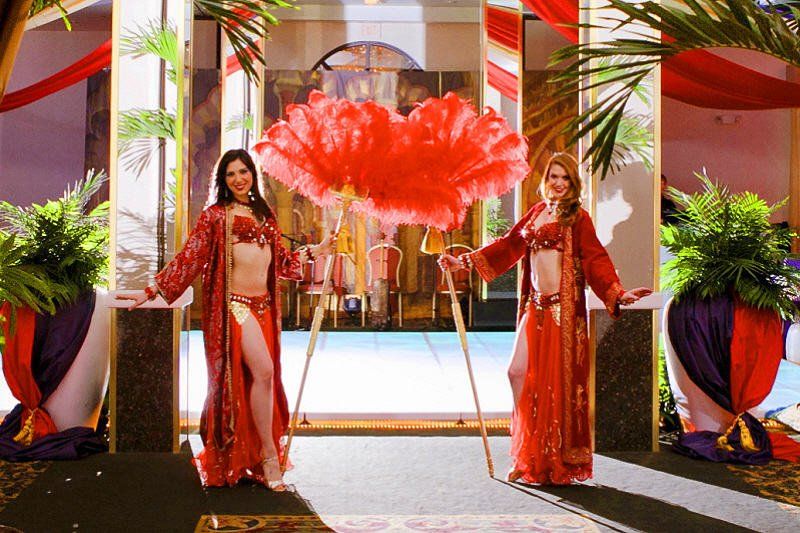 Meet and Greet entertainment image showing  two belly dancer greeters with feather fans