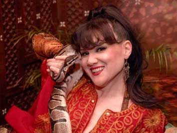 a woman is holding a snake in her hand and smiling.