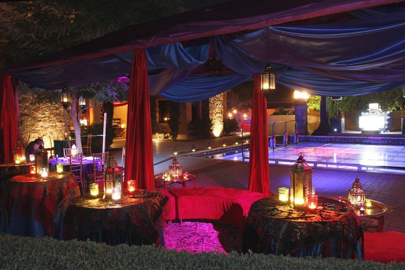 Tents and canopies image showing a draped canopy setting at poolside at night with lighting