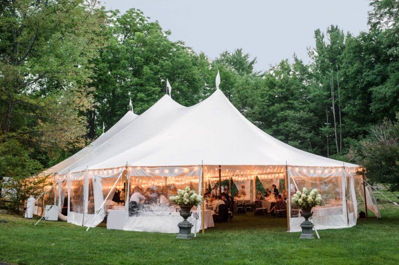 a large white tent is set up for a wedding reception