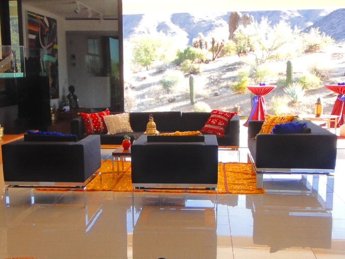 a living room with a couch and two chairs decorated with moroccan style pillows