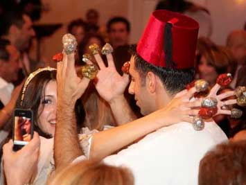 a man and a woman are dancing with henna on their fingers .