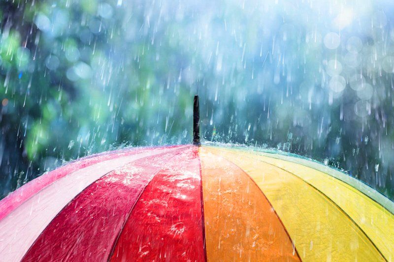 a brightly colored umbrella is in the rain