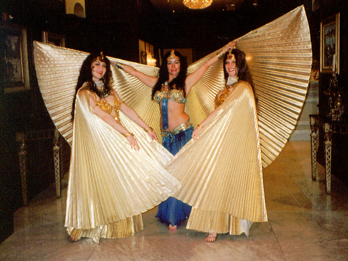 three women wearing gold wings are posing for a picture