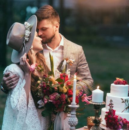 Bohemian couple by bridal cake