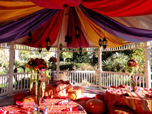 a colorful gazebo with lanterns hanging above decorative tables