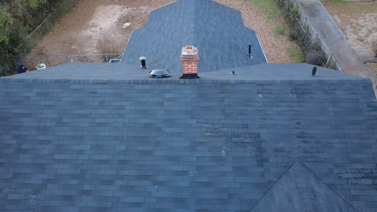 The roof of a house with two windows on it.