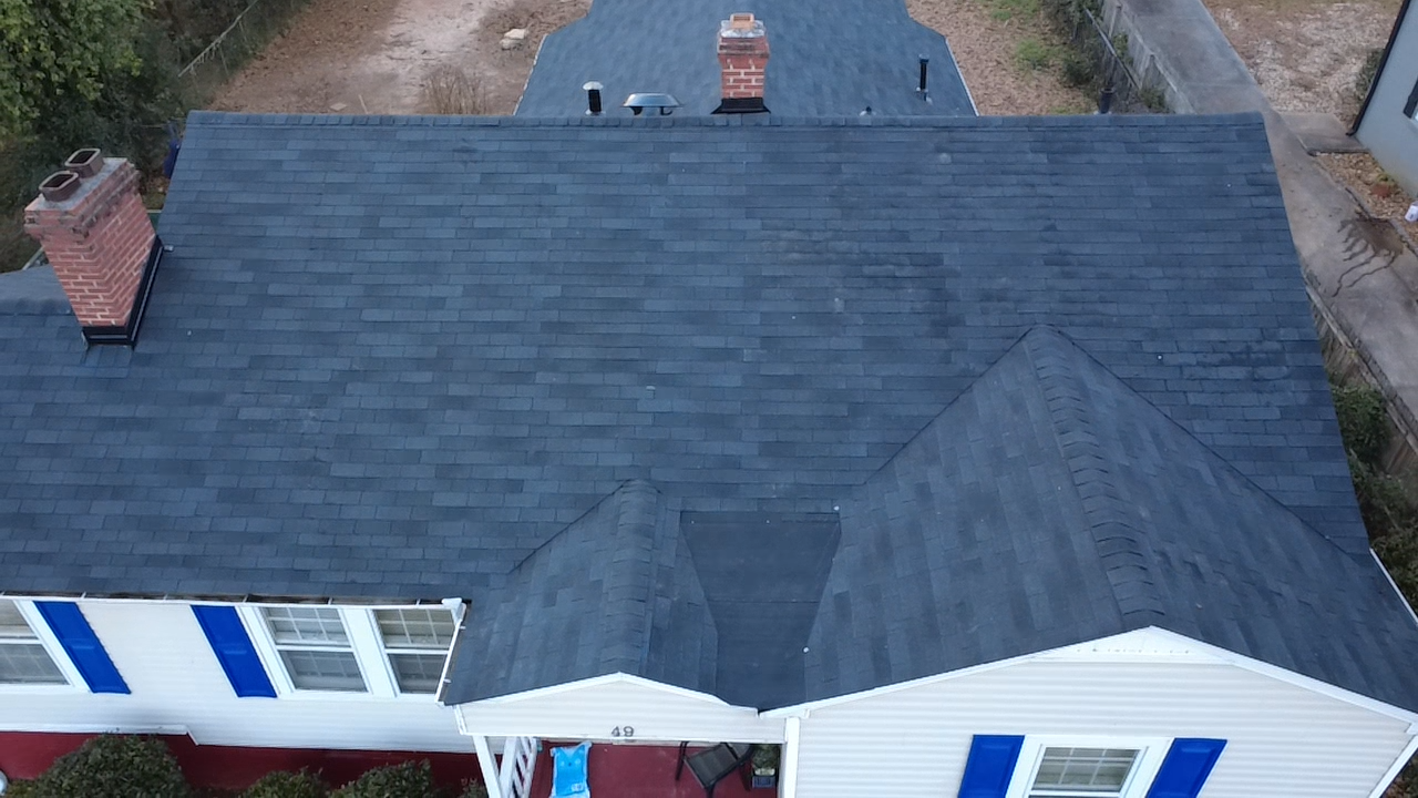 A large house with two garage doors and a driveway in front of it.