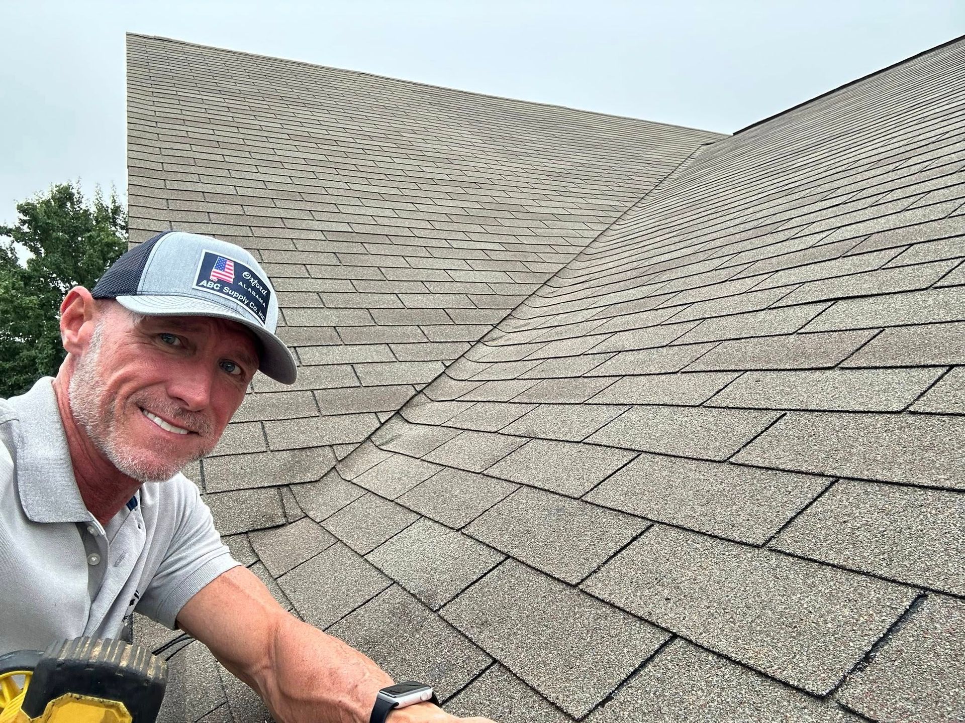 A man wearing a hat and gloves is standing on a roof.