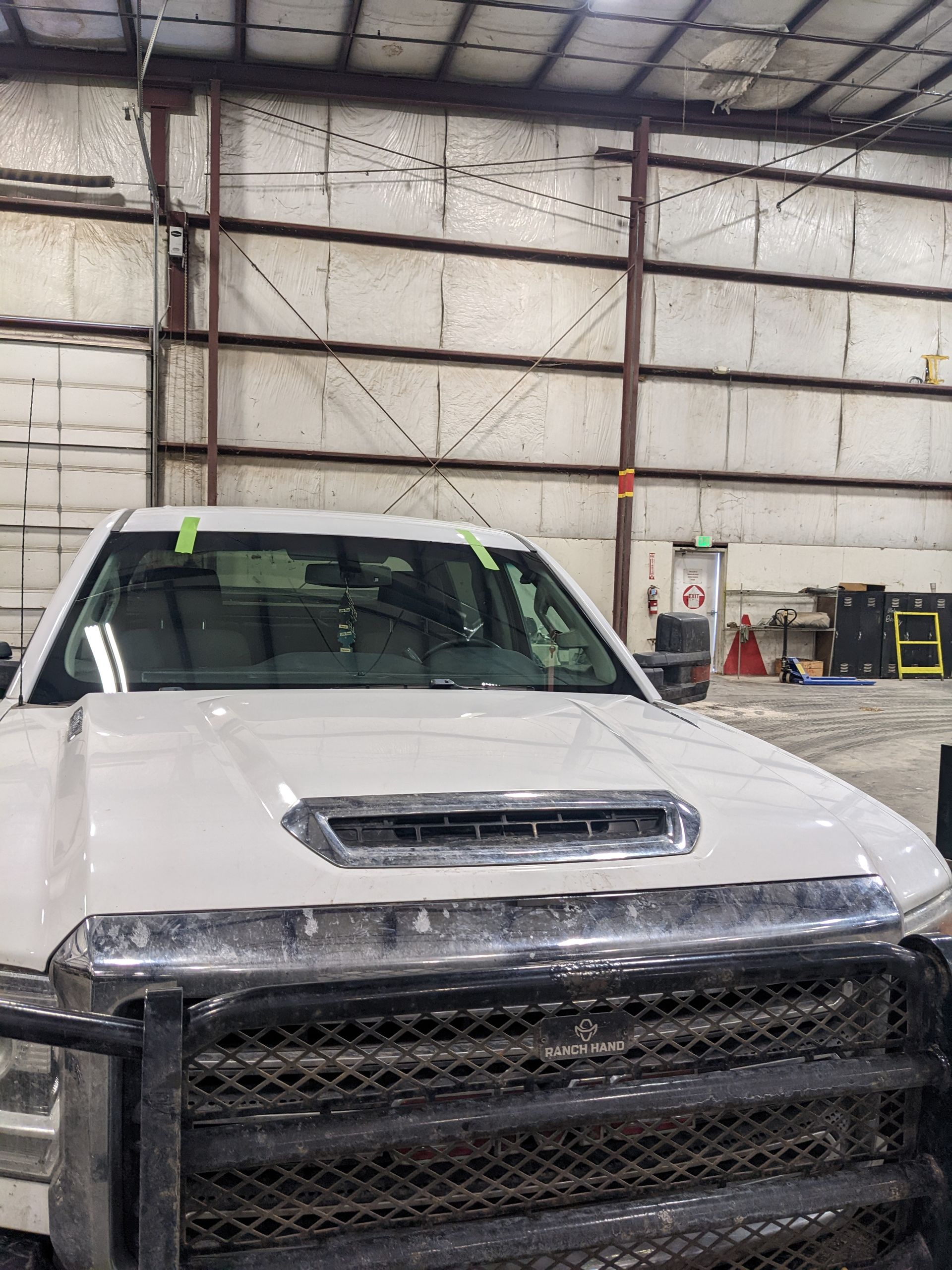 A white truck is parked in a warehouse.