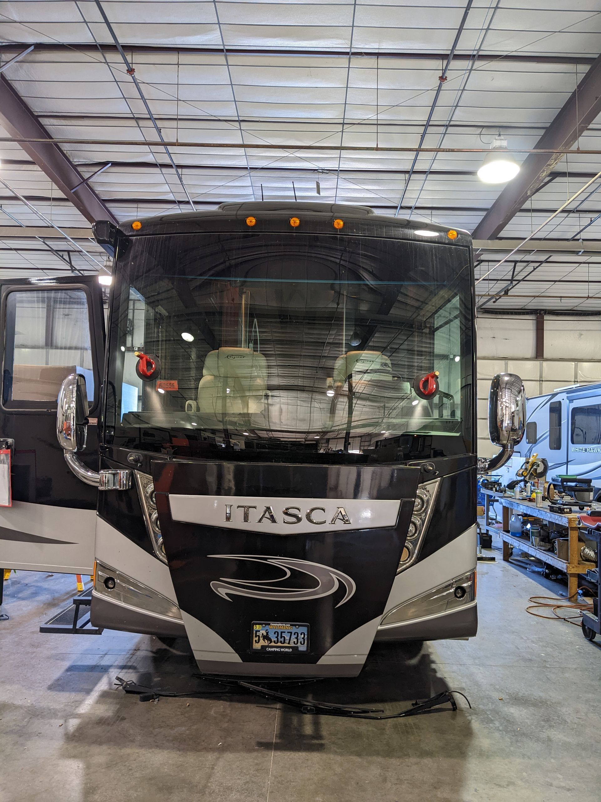 A black and white bus is parked in a garage.
