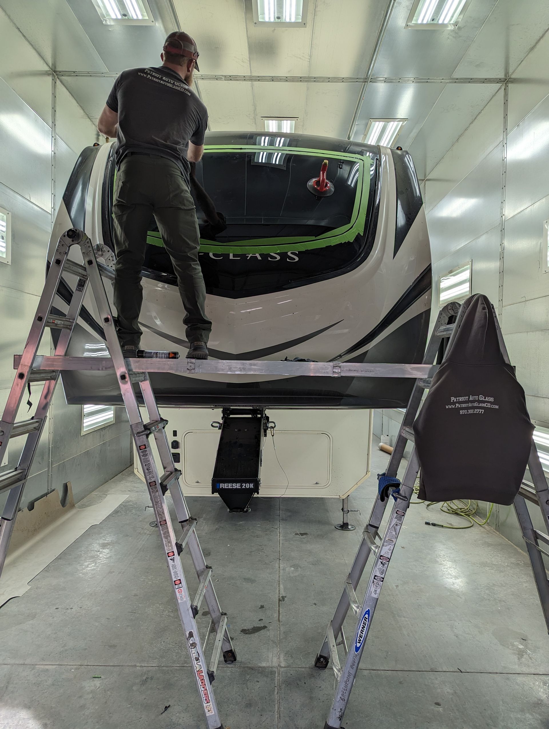 A man is standing on a ladder working on a trailer.
