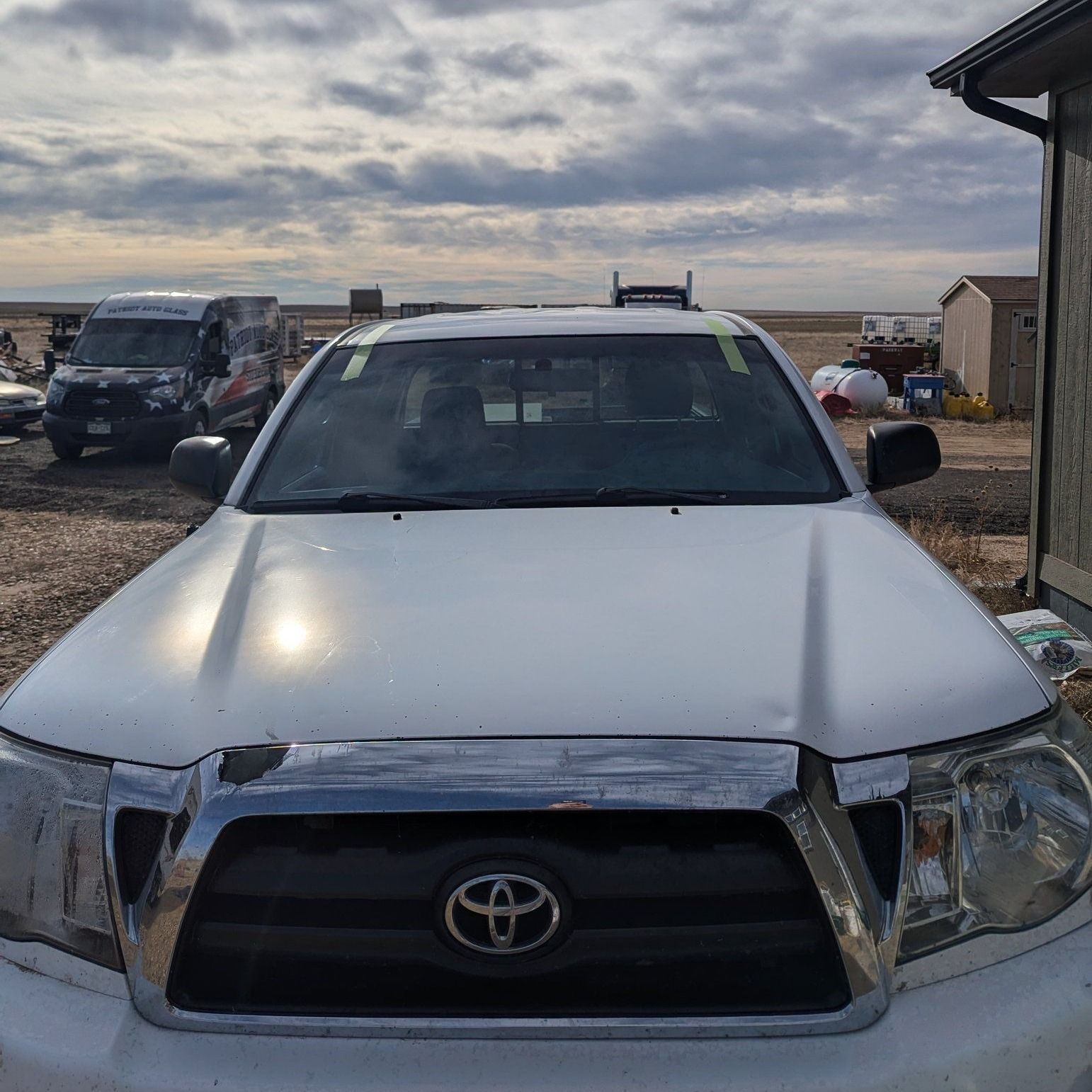 A white toyota truck is parked in front of a building