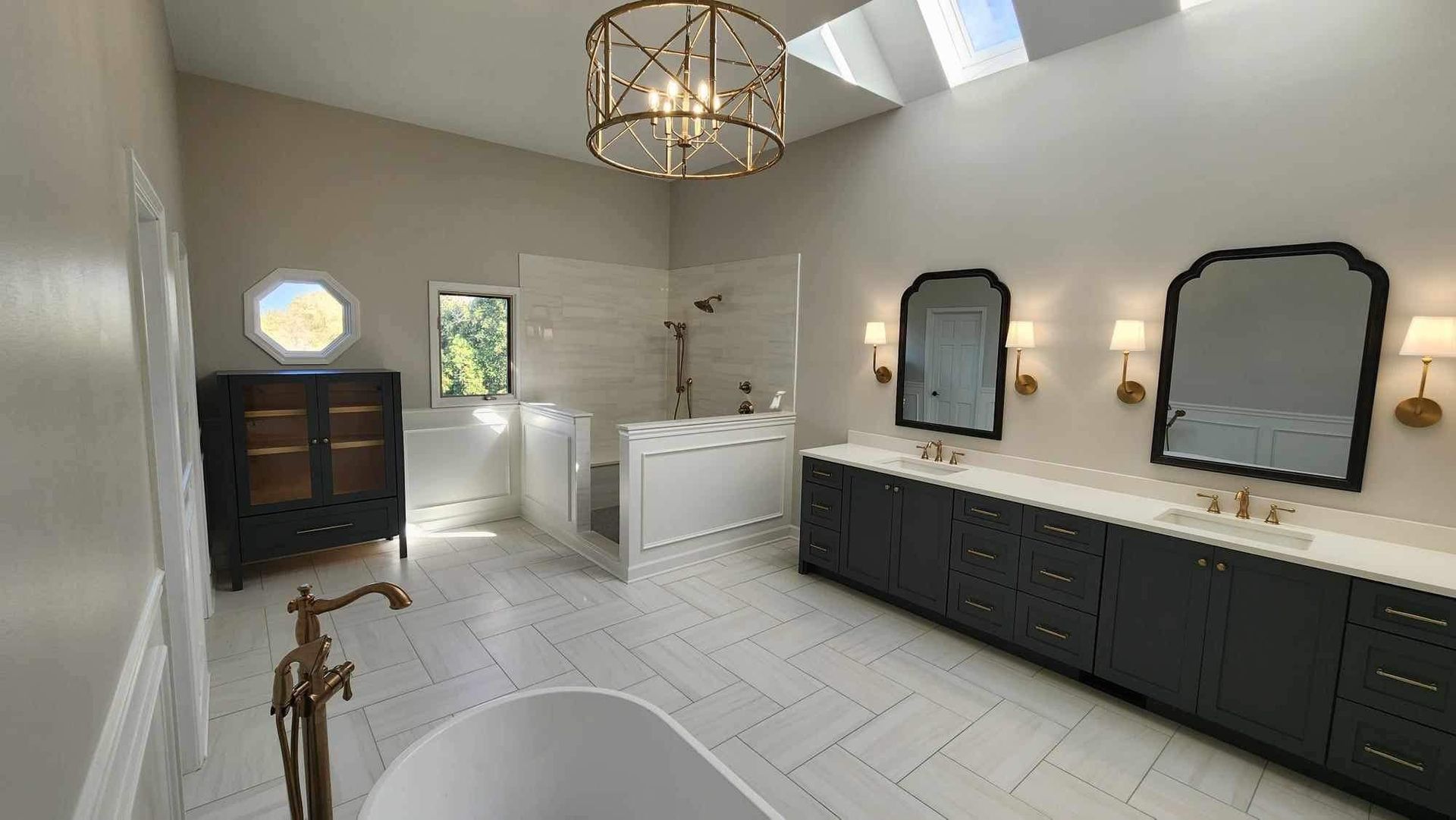 A worker uses a power drill on a bathroom wall panel under construction, featuring white marble tiles and drywall.