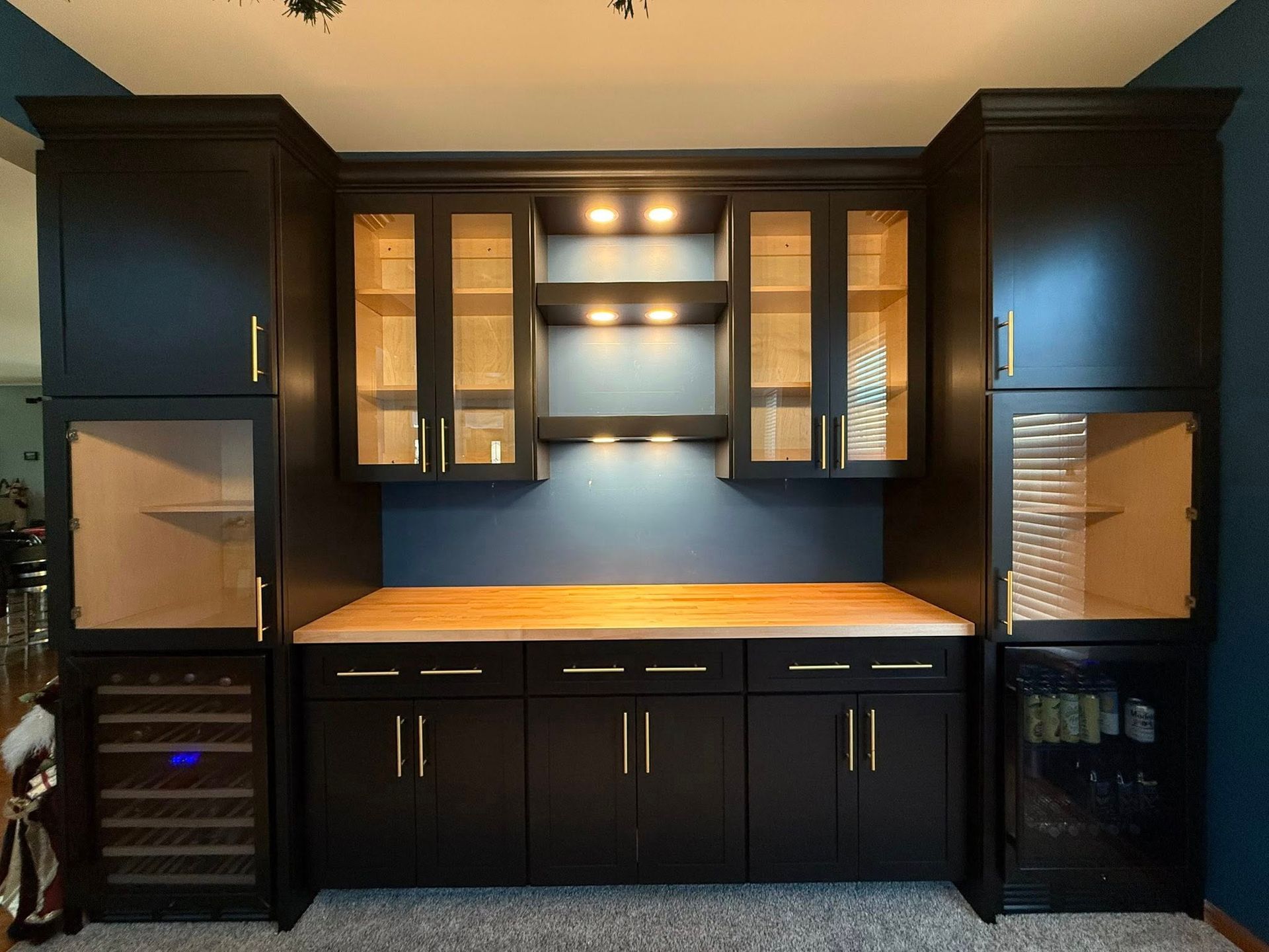 A kitchen under renovation with dark blue cabinets, white countertops, and protective paper covering the floors.