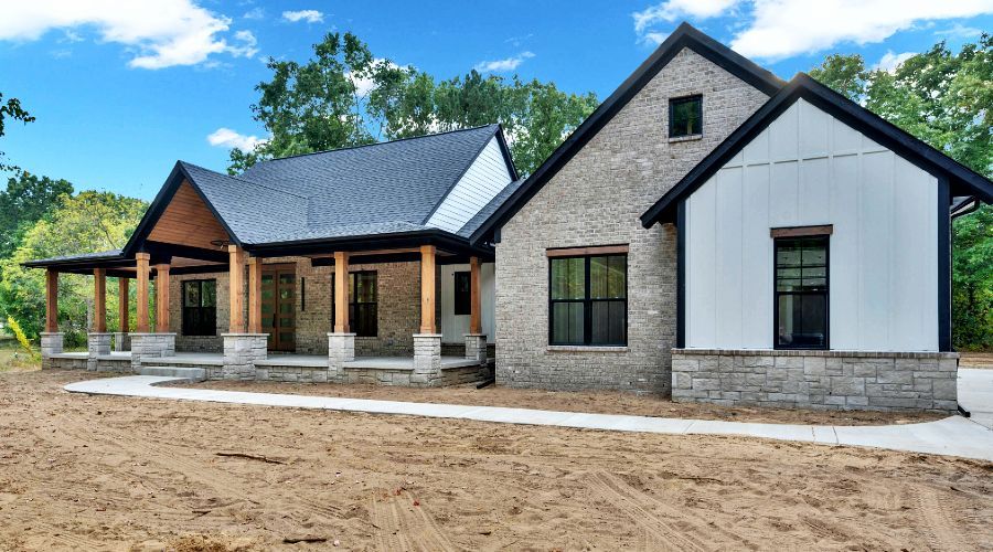 Exterior of new construction home with wood overhang beams and stone fascia