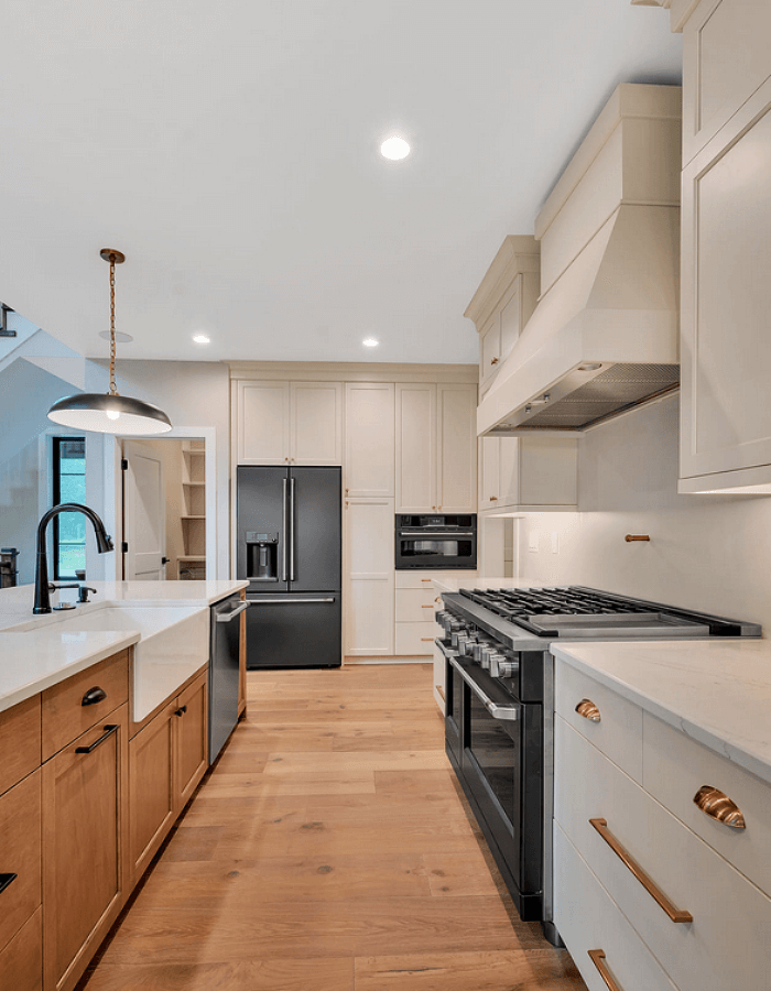 Kitchen with creme colors cabinets and stove hood
