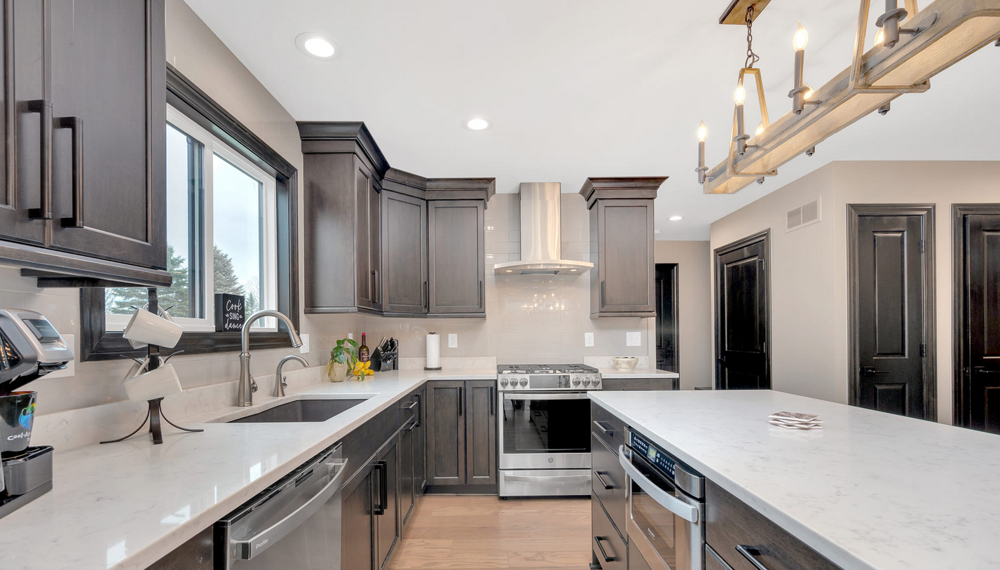 Kitchen with brown built in cabinetry and inset lighting