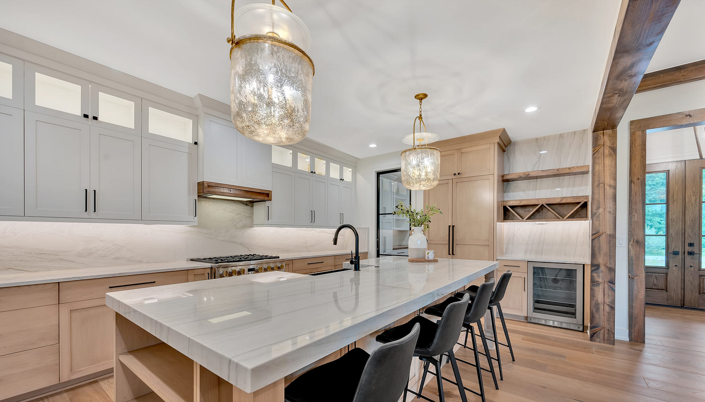 Kitchen with marble top island and elegant glass lighting