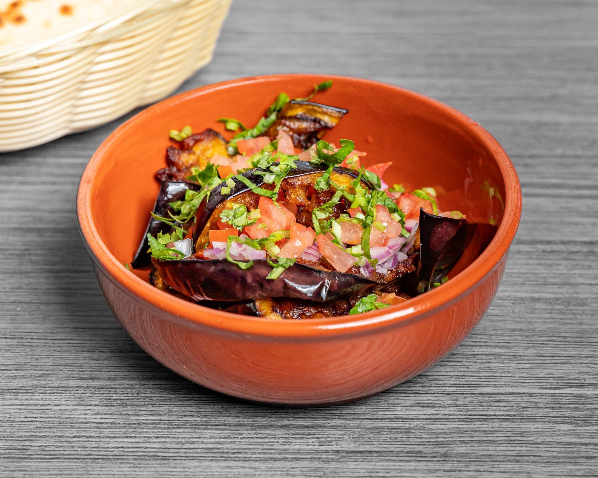 Fried eggplant salad in a bowl on table