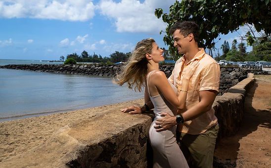 A man and a woman are standing next to each other on the beach.