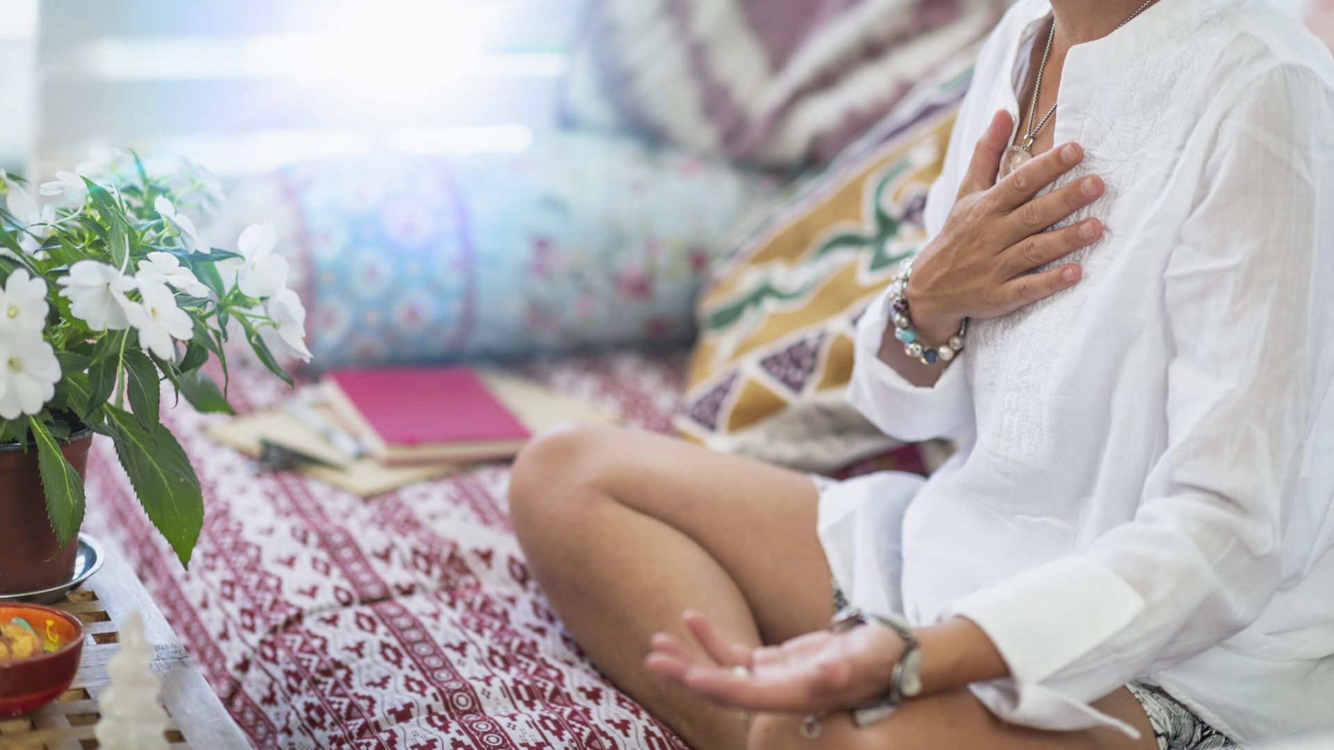 person in meditation holding their chest for self reiki