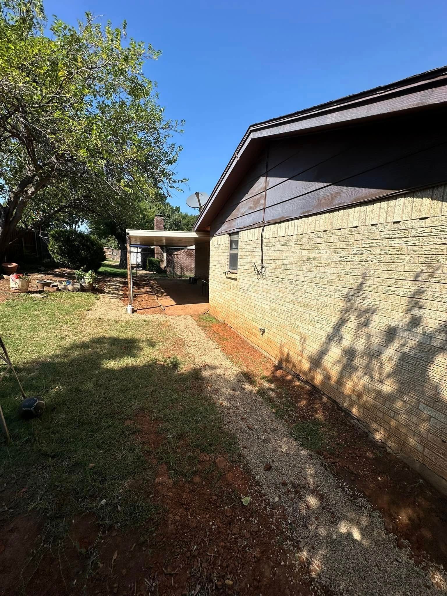A house with a driveway leading to it and a tree in the backyard.