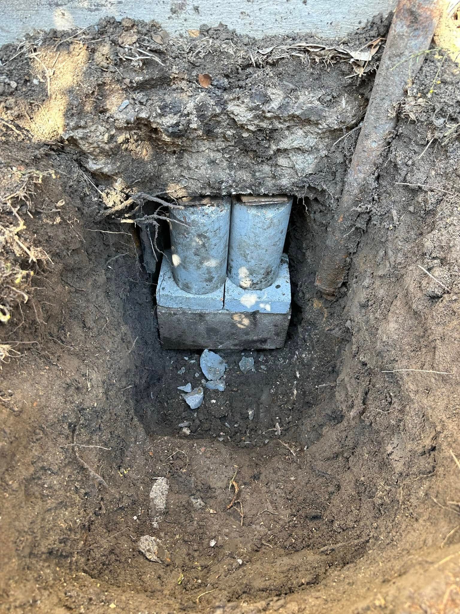 A concrete block is sitting in the middle of a hole in the ground.