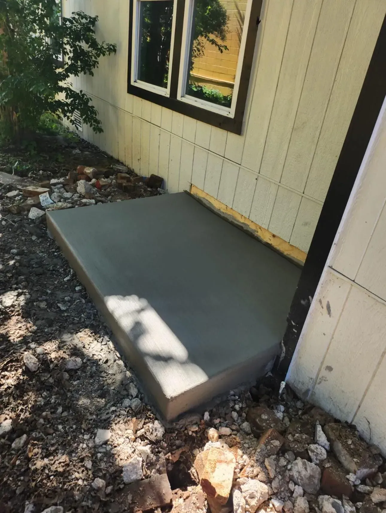 A concrete step is being built in front of a house.