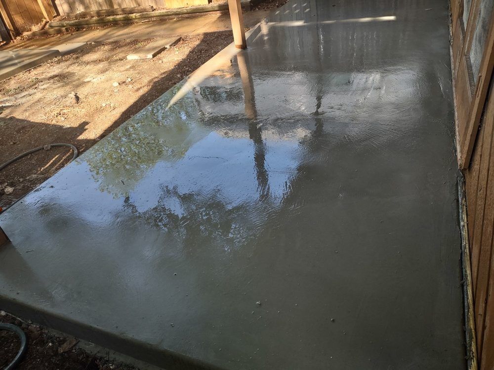 A concrete floor with a reflection of trees in it.