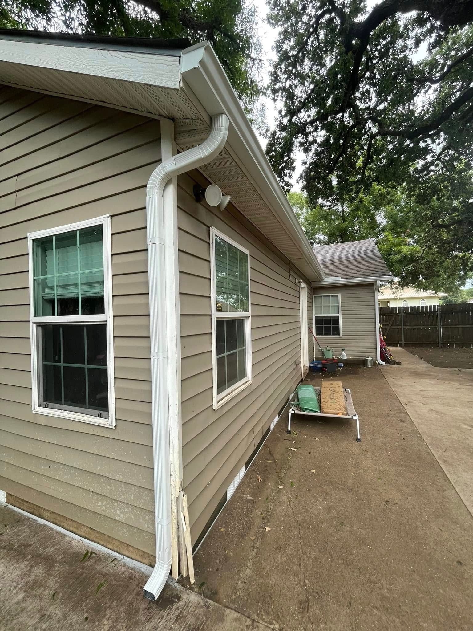 A house with a lot of windows and a gutter on the side of it.