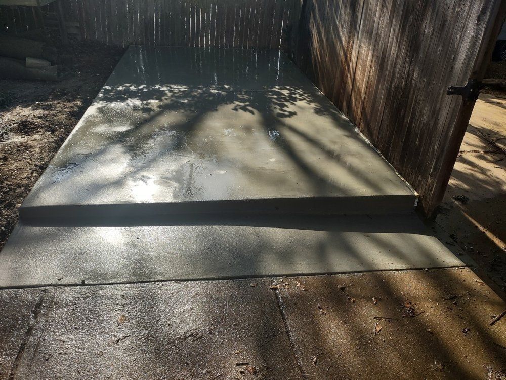 A concrete walkway with steps leading to a wooden fence.