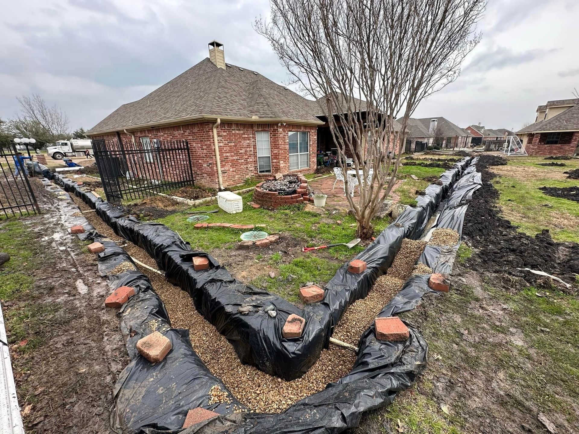 A drainage system is being built in the backyard of a house.