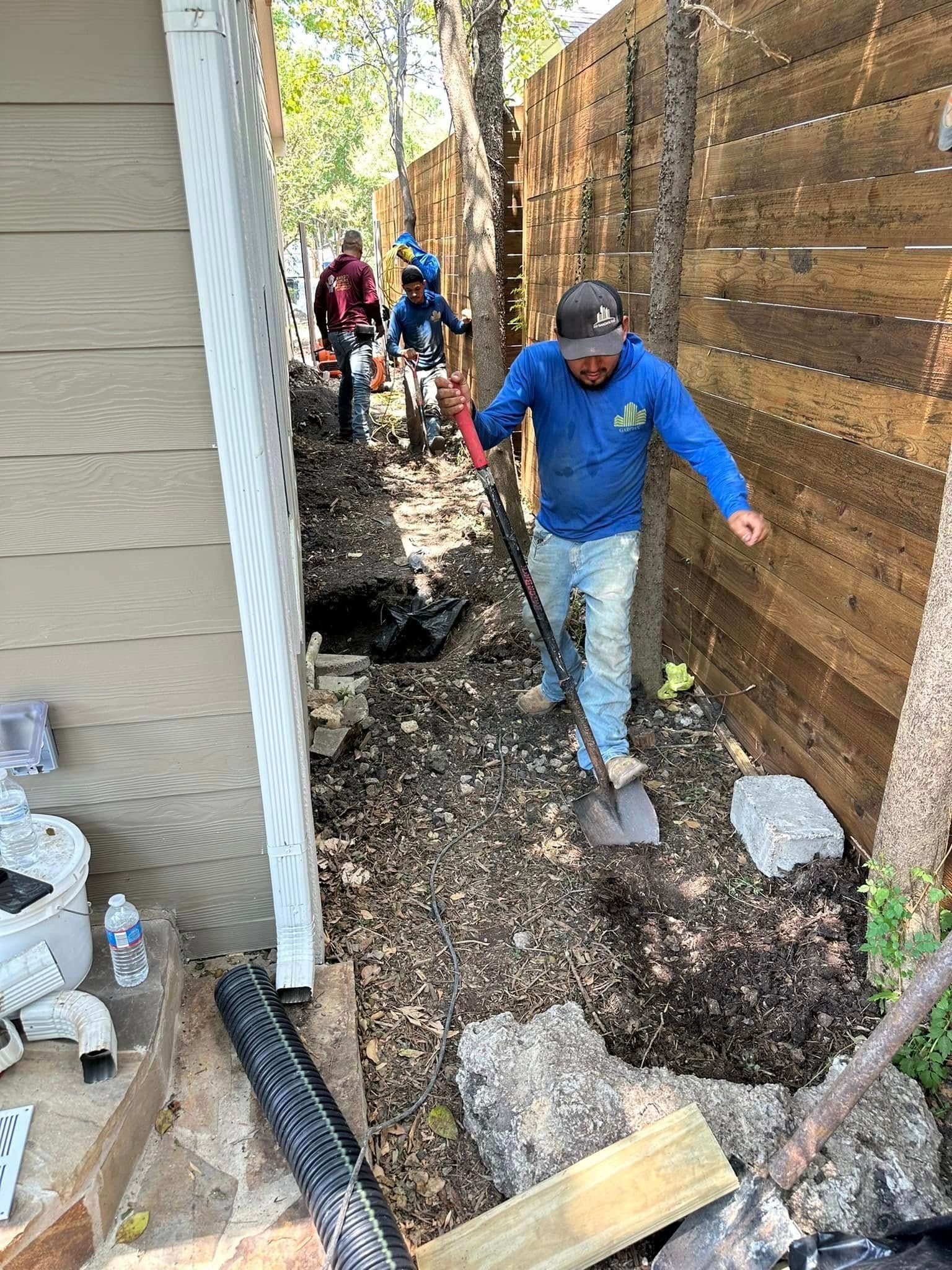 A man is digging a hole in the ground with a shovel.