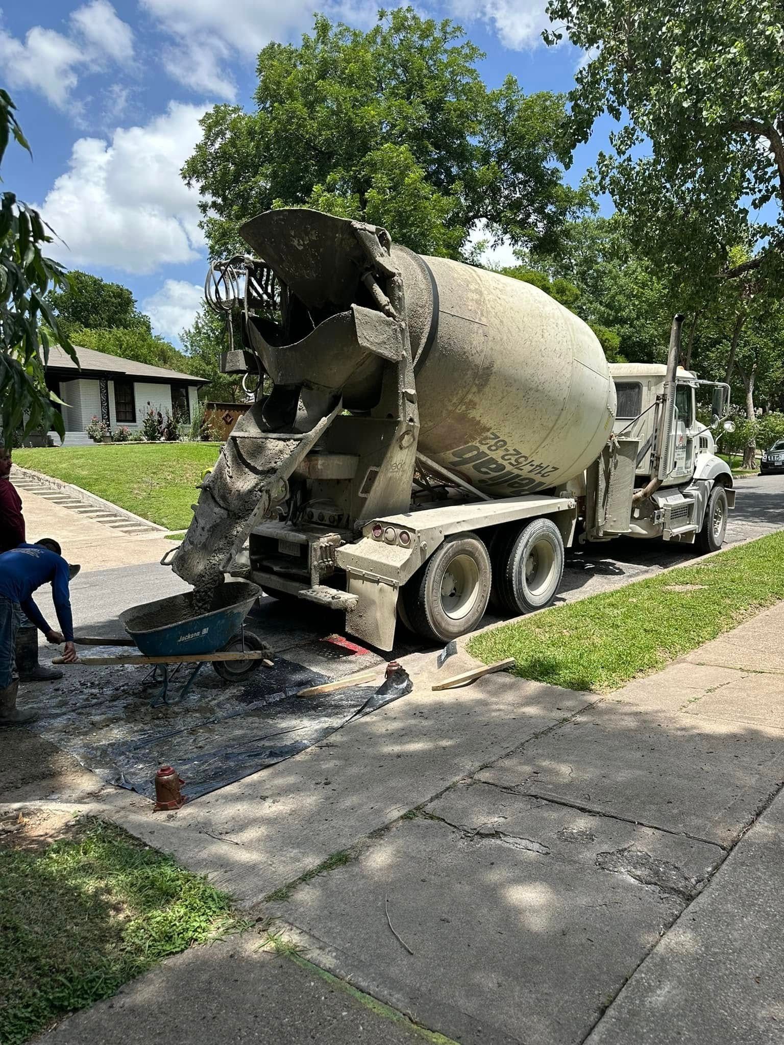 A concrete mixer truck is parked on the side of the road.