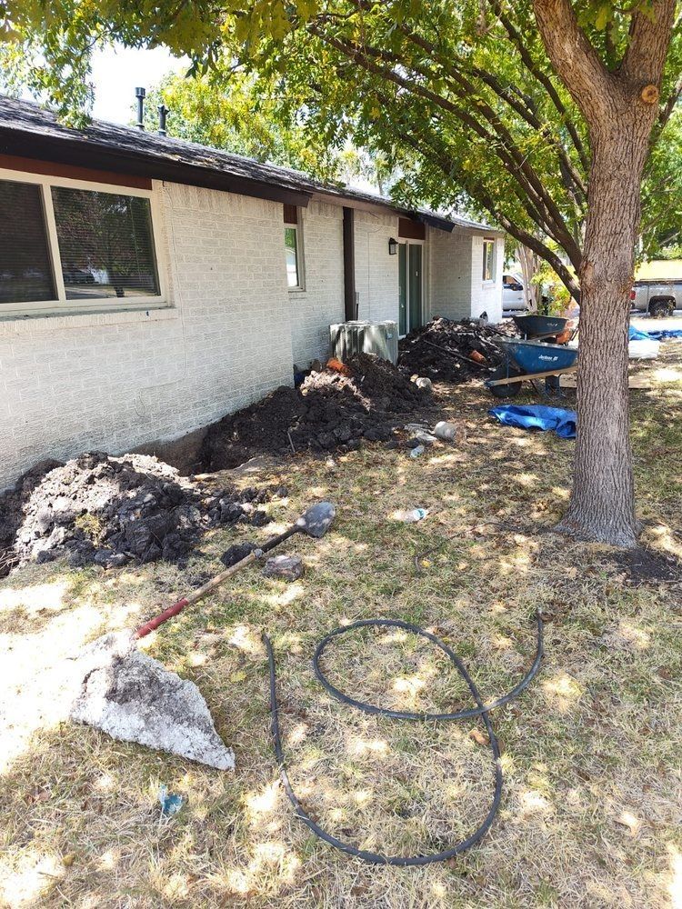 A house with a lot of dirt in front of it and a tree.