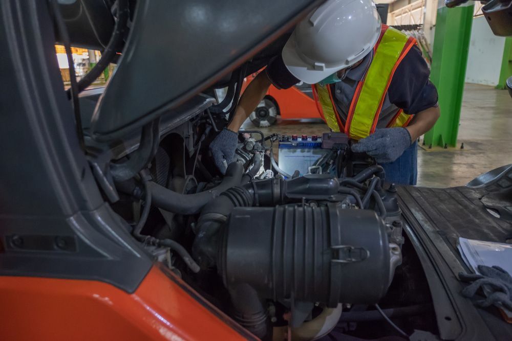 A Man is Working on the Engine of a Forklift — Chris Bale Automotive in Toronto, NSW