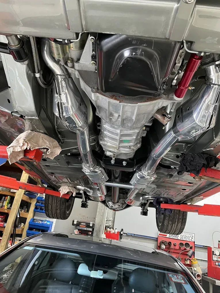 A Man is Working on a Car Engine While a Woman Writes on a Clipboard — Chris Bale Automotive in Toronto, NSW