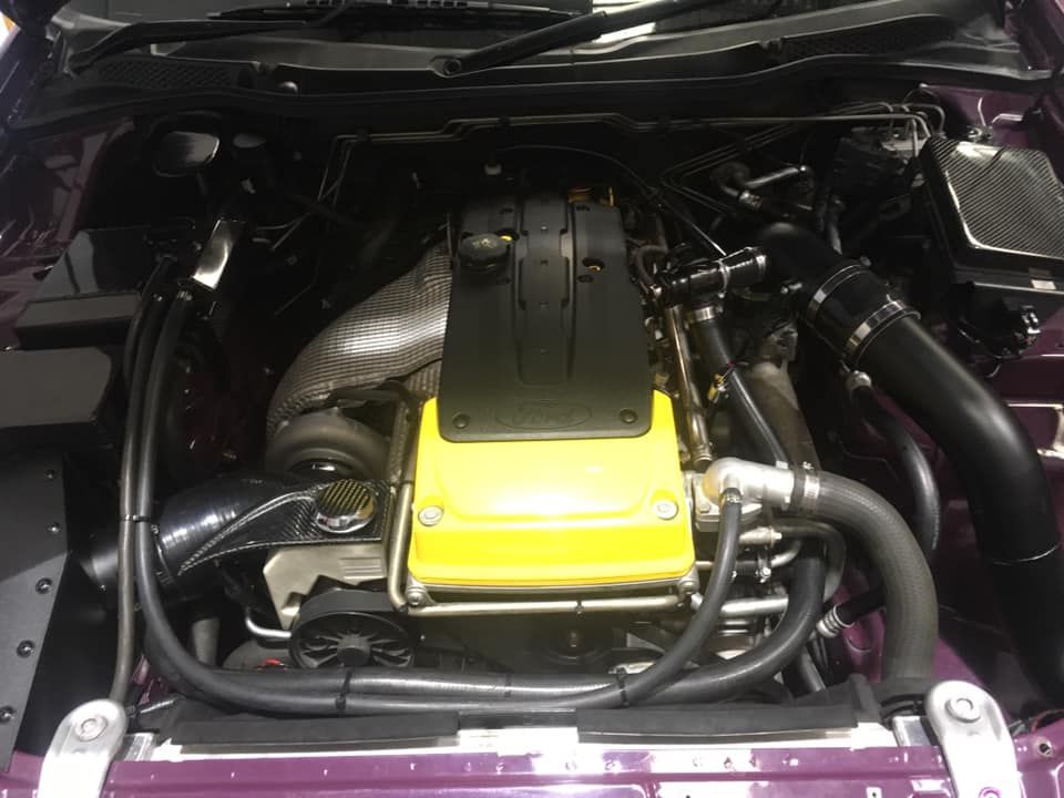 Yellow-top inline 6 engine in a purple engine bay. — Chris Bale Automotive in Toronto, NSW