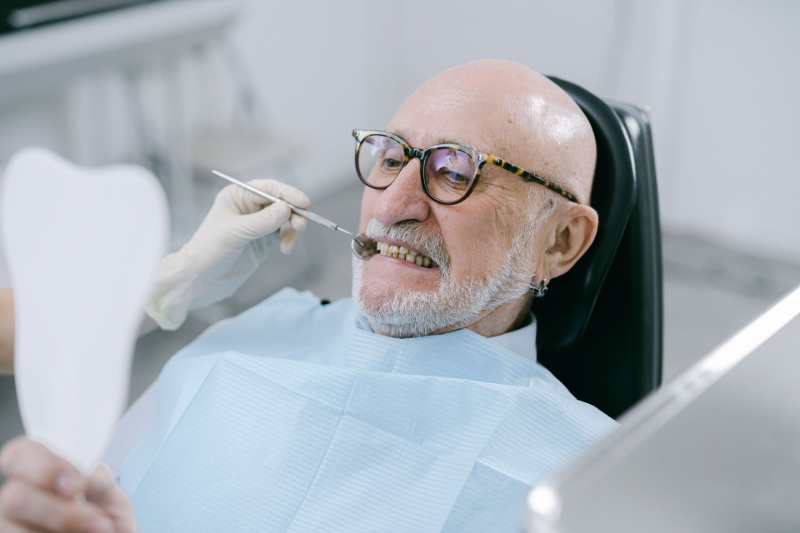 Hands adjusting a dental model with tools in a clinic workspace