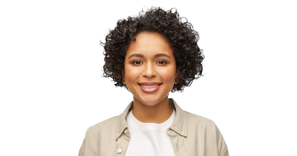 A woman with curly hair is smiling for the camera.